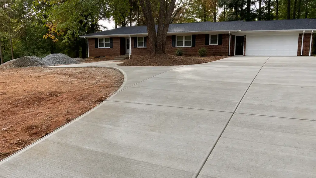 cement installation completed by a local contractor at a red-brick ranch home in Alpharetta, GA, under bright midday cloud.