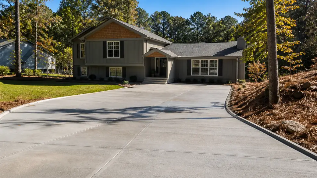 commercial concrete construction completed by a local contractor at a grey split-level home in Alpharetta, GA, in clear late-morning sun.