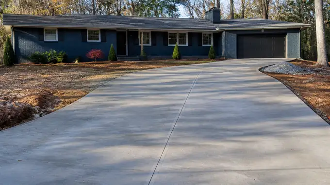 concrete installation completed by a local contractor at a buff-brick ranch home in Alpharetta, GA, under low winter sun.