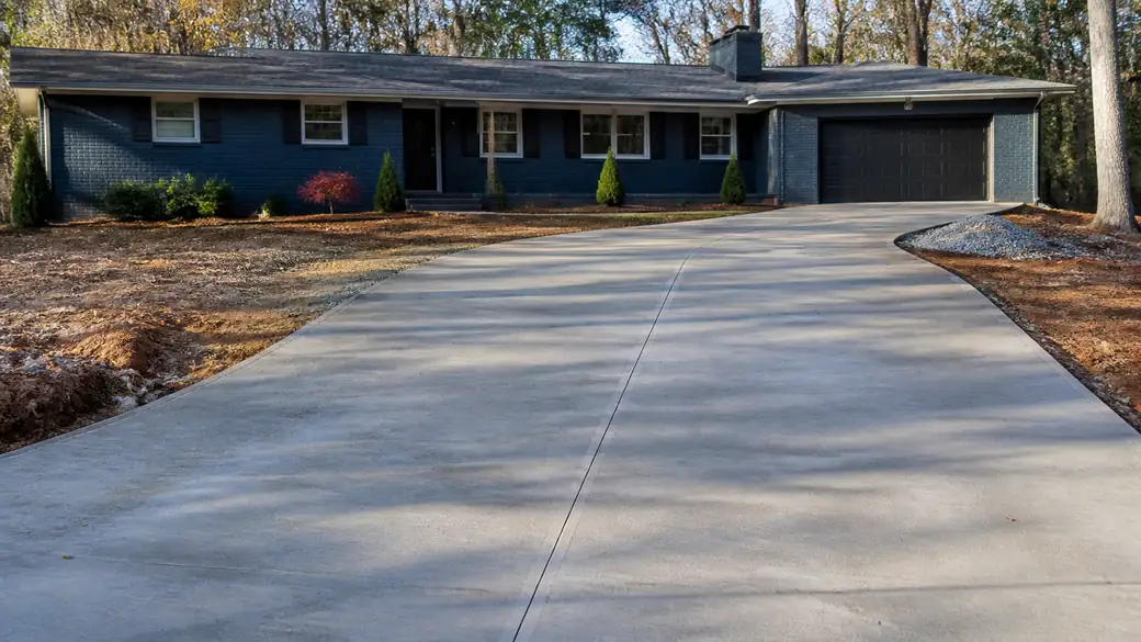 concrete installation completed by a local contractor at a buff-brick ranch home in Alpharetta, GA, under low winter sun.