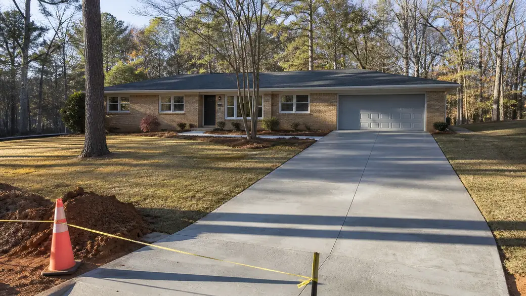 concrete repair services completed by a local contractor at a buff-brick ranch home in Alpharetta, GA, under low winter sun.
